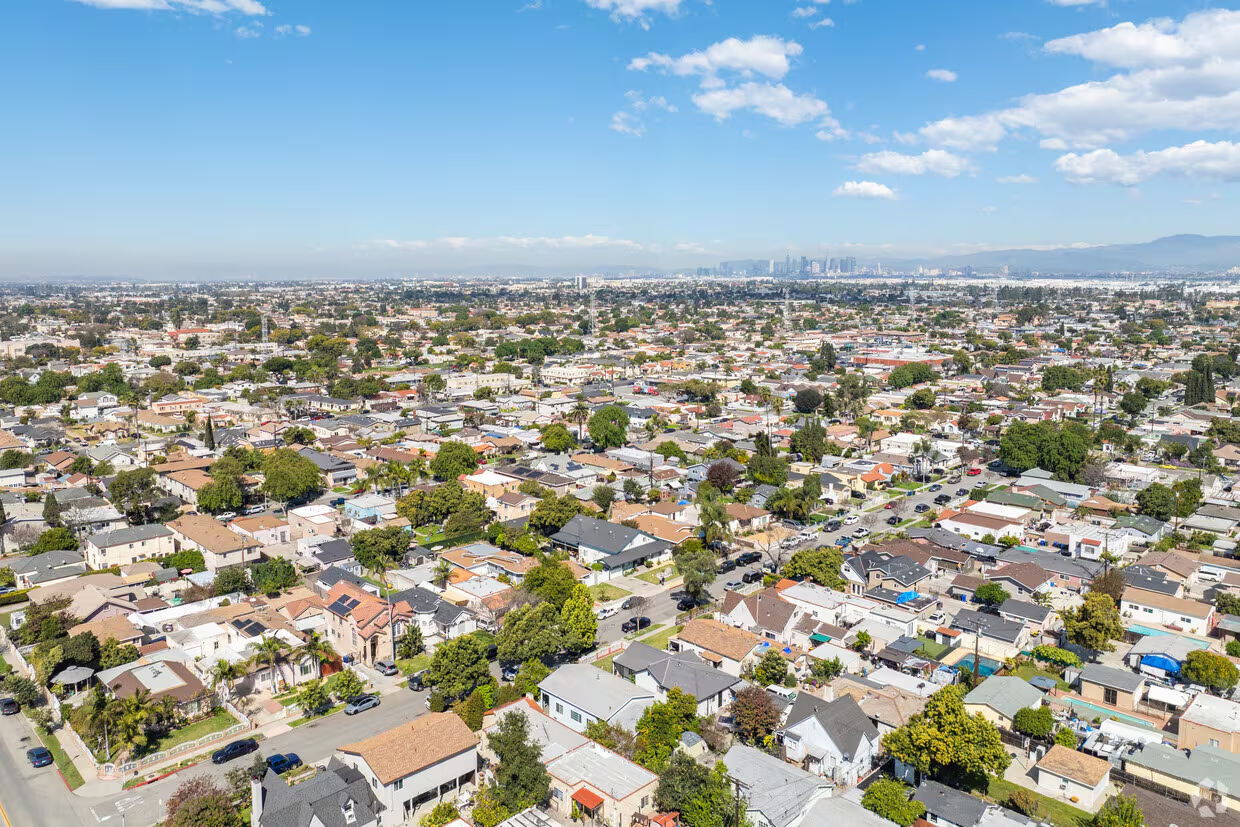 Residential street with palm trees and stucco bungalows in South Gate, California at golden hour